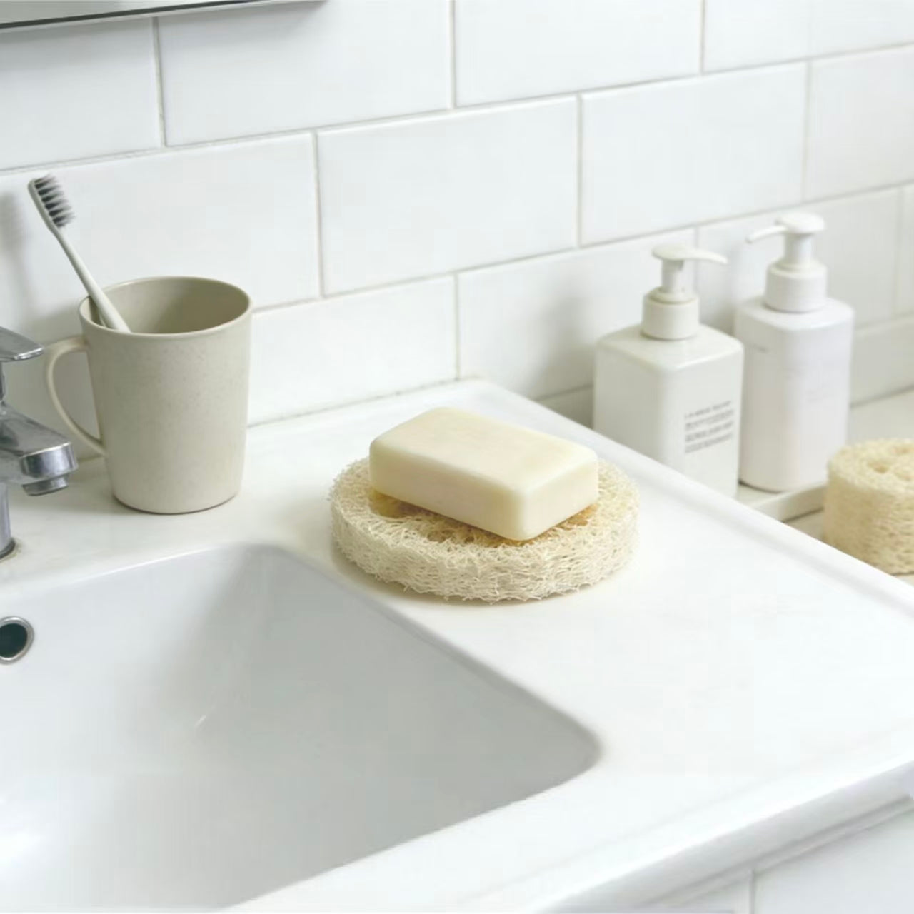 Natural loofah soap saver pad on bathroom counter, plastic-free plant fiber soap rest for handmade soap