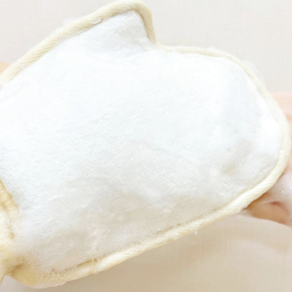 Rich soap lather created on organic loofah shower mitt for deep skin cleaning