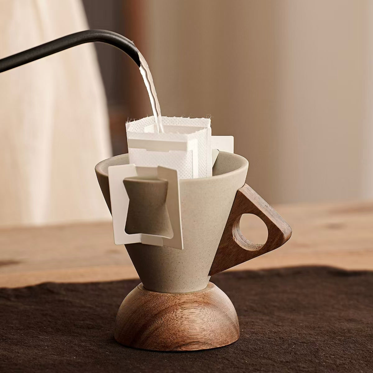 Speckled stoneware pour over dripper brewing hanging ear coffee, wooden handle round base, minimalist neutral kitchen scene, sustainable coffee making tool 