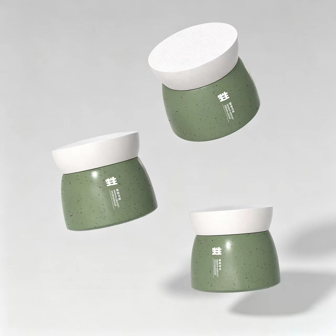 Three green compostable skincare cream jars with white textured lids floating in the air against a neutral gray background.
