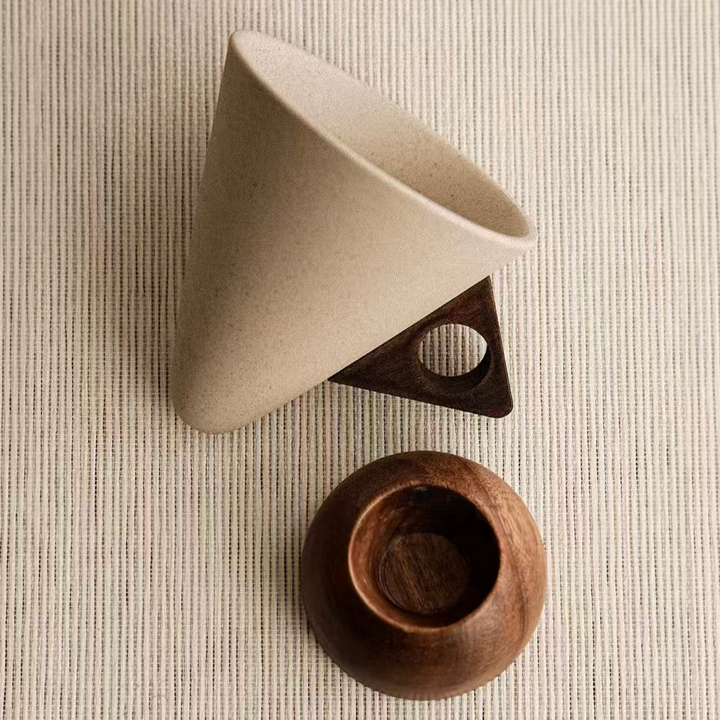 Handmade conical ceramic coffee filter cup separated with solid wood stand flat lay shot, wabi sabi neutral tone home coffee accessory, plastic-free eco coffee dripper 