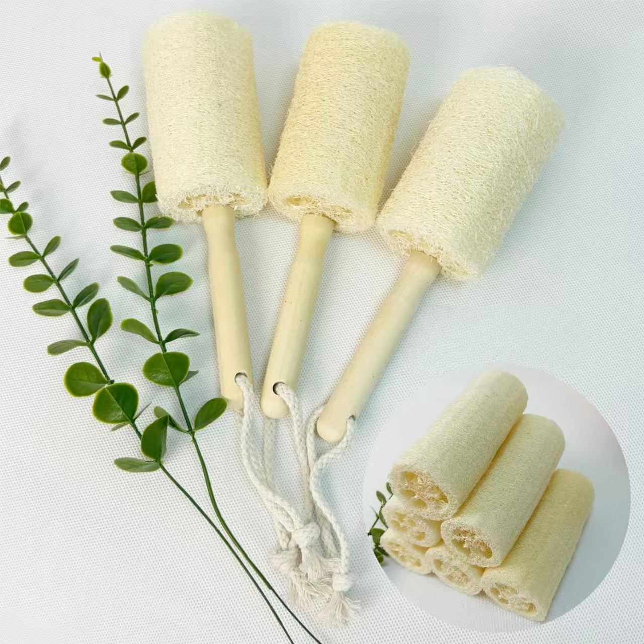 Wood handle loofah bottle cleaning brush styled with fresh green foliage, eco sustainable kitchen scrubber
