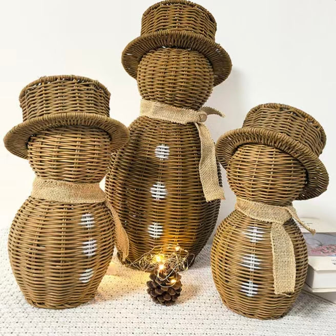  A set of three eco-friendly handwoven rattan snowmen in small, medium, and large sizes standing together as a Christmas holiday home decor centerpiece.