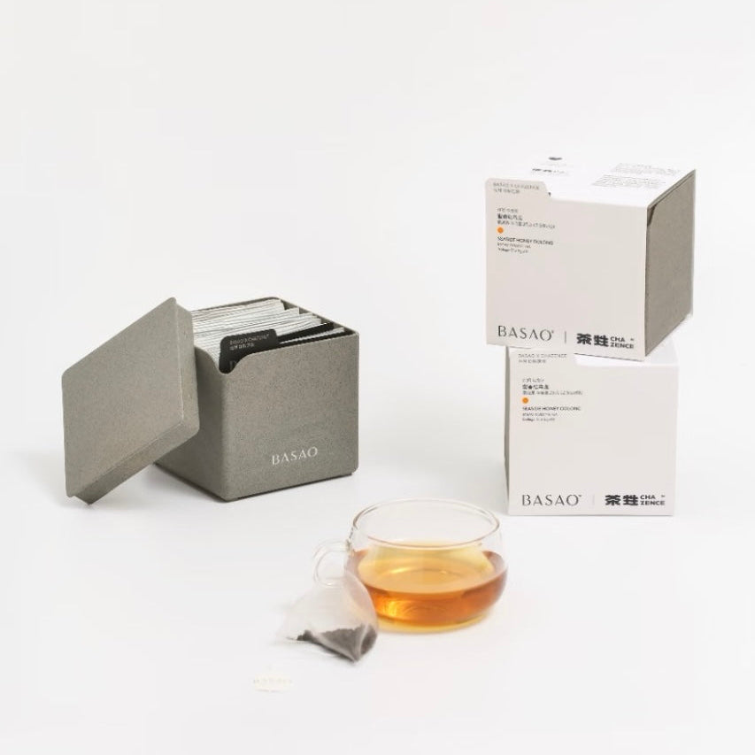 Minimalist food-grade premium tea gift boxes and biodegradable nitrogen-flushed tea sachets made from eco-friendly tea fiber composite material, displayed with a clear glass tea cup.⁠
