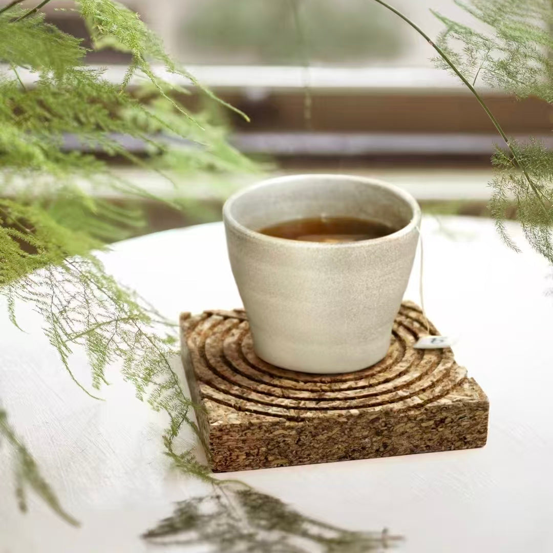 Ceramic tea cup placed on a natural bio-composite tea fiber pressed panel coaster