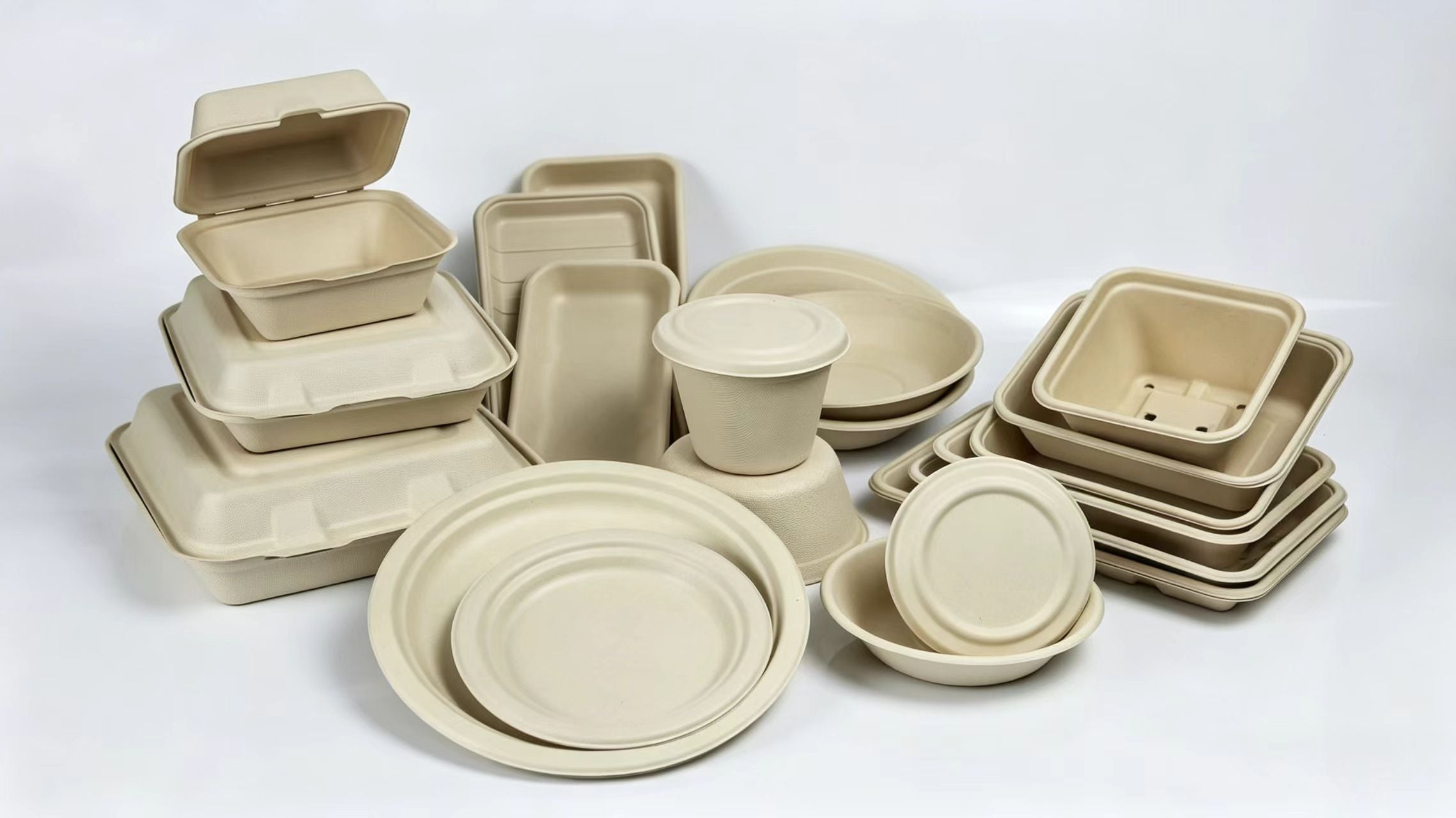   A collection of Xuran Eco unbleached sugarcane bagasse tableware, including compostable clamshell food containers, biodegradable plates, bowls, and supermarket trays for catering wholesale.